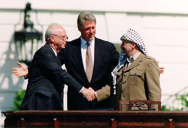 Israeli Prime Minister Yitzhak Rabin and head of the PLO Yasser Arafat shake hands at the White House, 1993. Public Domain.